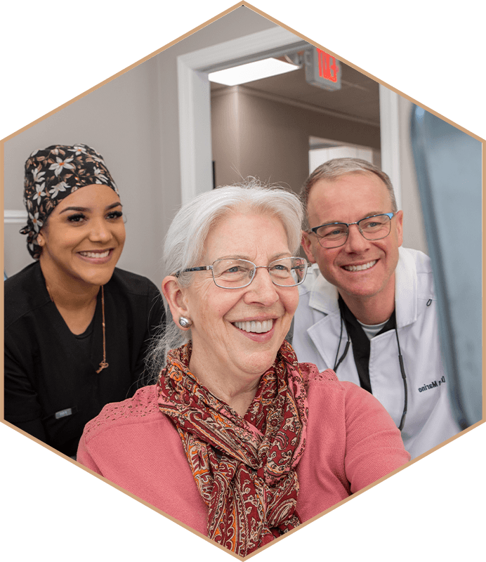 Dr. Brian Marino and a team member smiling with a patient at Pequannock Valley Dental Associates in Pompton Plains, NJ